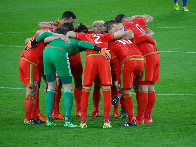 Die walisische Fußball-Nationalmannschaft schwört sich ein (hier vor dem Freundschaftsspiel gegen die Niederlande im November 2015) – CC BY-SA 2.0: Jon Candy, (ohne Titel), https://www.flickr.com/photos/joncandy/21959436558/