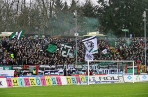 Die vollbesetzte Fiffi-Gerritzen-Kurve, Heimat der Münsteraner Ultras und benannt nach Felix „Fiffi“ Gerritzen, der 1951 mit dem SC Preußen im Finale um die Deutsche Meisterschaft stand. – CC BY-NC 2.0: Groundhopping Merseburg, „Preußen Münster v Dynamo Dresden, https://www.flickr.com/photos/fchmksfkcb/15804486984/in/album-72157650189620307/ 